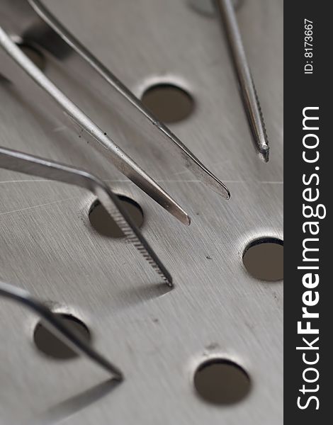 Assorted tweezers tips on a metal workbench