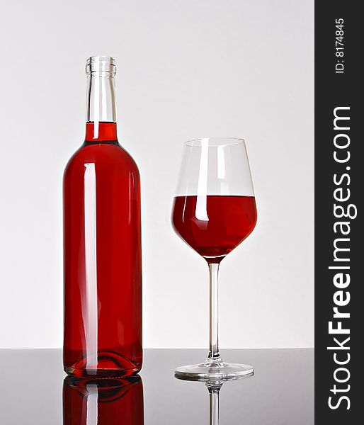 Glass of red wine and bottle over white background. Glass of red wine and bottle over white background