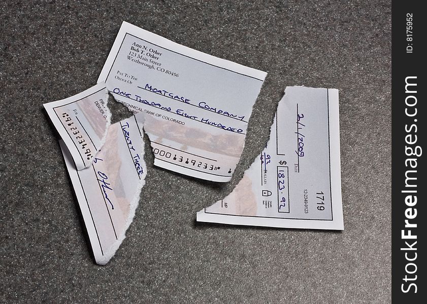 A mortgage payment check torn into pieces. The check is entirely original artwork and the routing number is deliberately too short. A mortgage payment check torn into pieces. The check is entirely original artwork and the routing number is deliberately too short.
