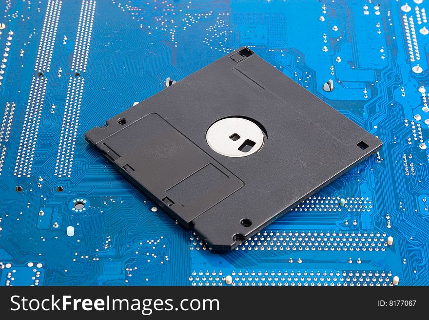 Outdated technology memories: black floppy disk on blue background