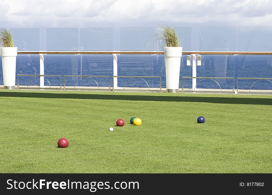 Colorful bocce balls on a green lawn on the deck of a ship at sea. Colorful bocce balls on a green lawn on the deck of a ship at sea