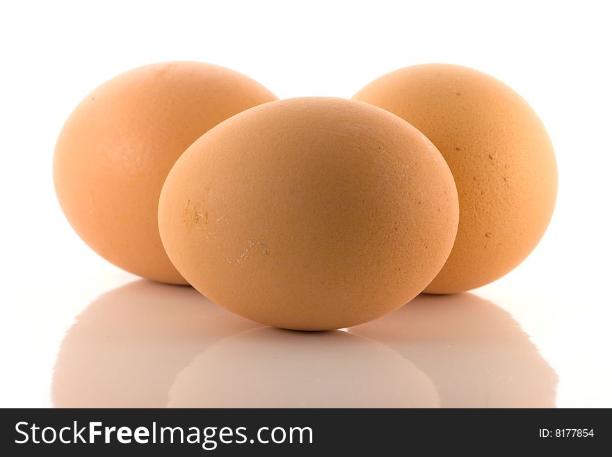 Group of three domestic chicken eggs, one in front and two behind. Group of three domestic chicken eggs, one in front and two behind