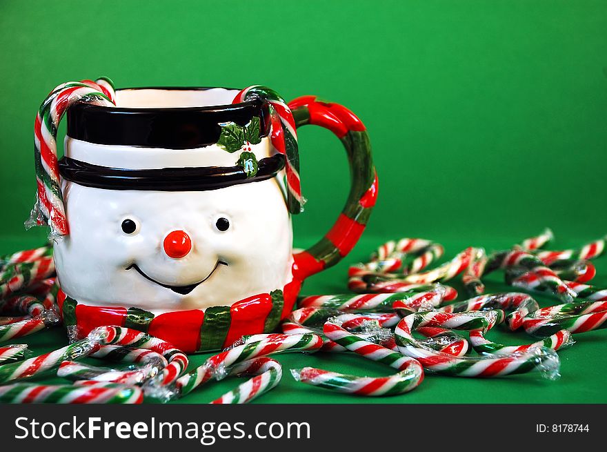 Snowman and candy canes on green background