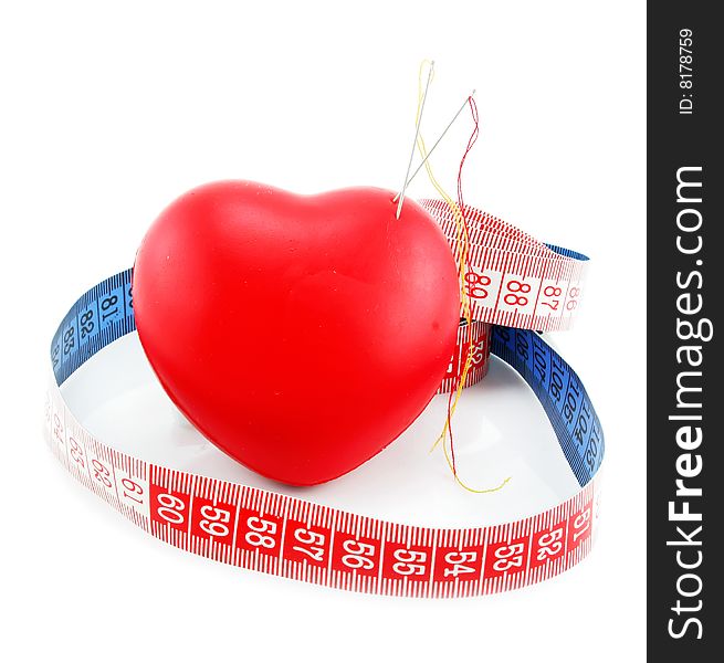 Heart shaped pincushion and measuring tape isolated on a white background