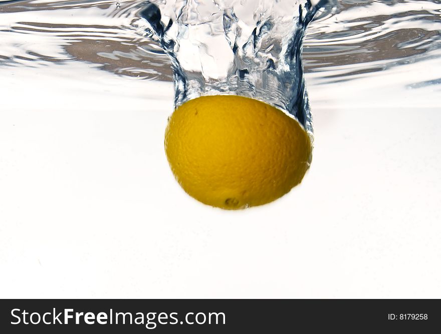 Orange falling into water with water splash