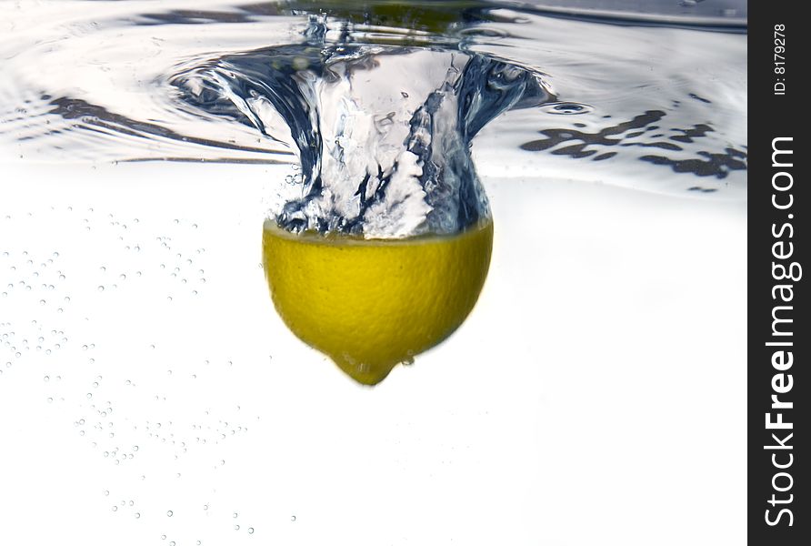 Lemon dropped into water with water splash