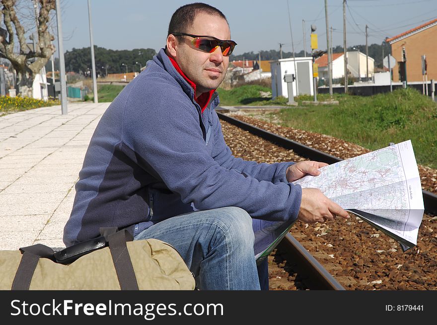 Men waiting for the train and looking a map