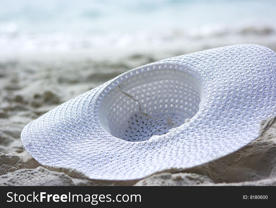 White hat lies on the beach sand. White hat lies on the beach sand