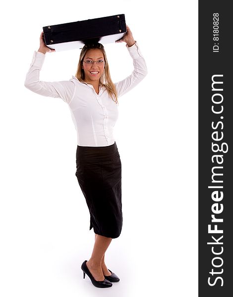 Side view of young businesswoman putting briefcase on her head against white background