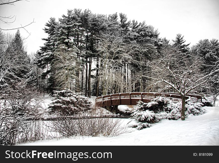 View of snow covered outdoor park with bridge over a stream.  Location is Armonk, NY. View of snow covered outdoor park with bridge over a stream.  Location is Armonk, NY.