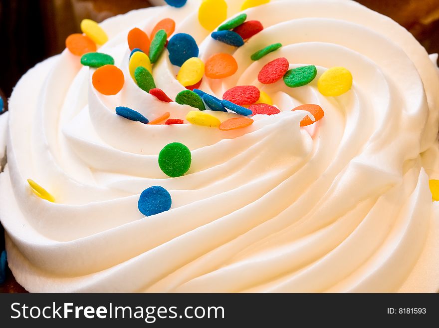 Freshly baked cupcakes close up with colored candies on the frosting