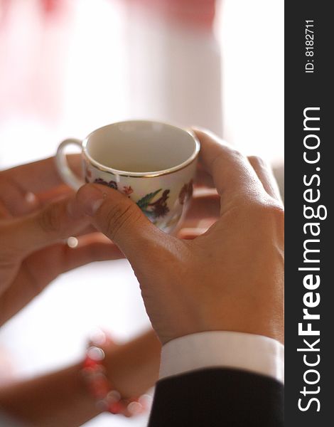 Hand holding a chinese wedding cup during wedding day. Hand holding a chinese wedding cup during wedding day