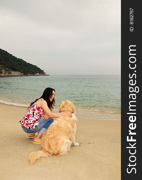 Young woman talking to her Dog in a tropical beach. Young woman talking to her Dog in a tropical beach