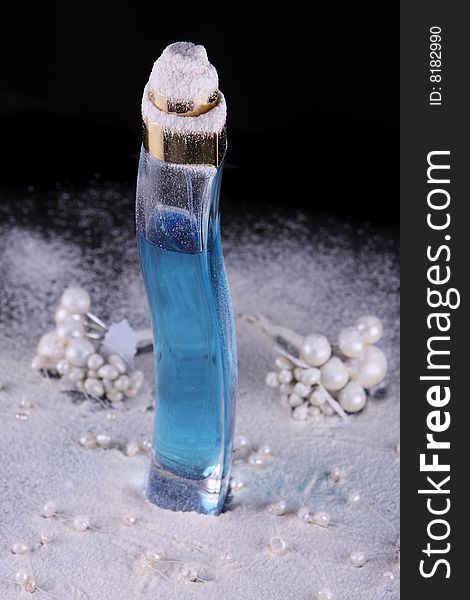 Tall perfume bottle with blue liquid in studio lighting