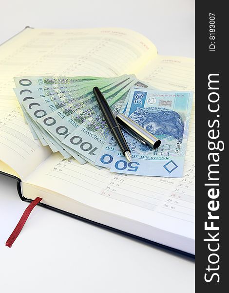 Money lying on the calendar. On top of a black pen and ferrule. Money lying on the calendar. On top of a black pen and ferrule.