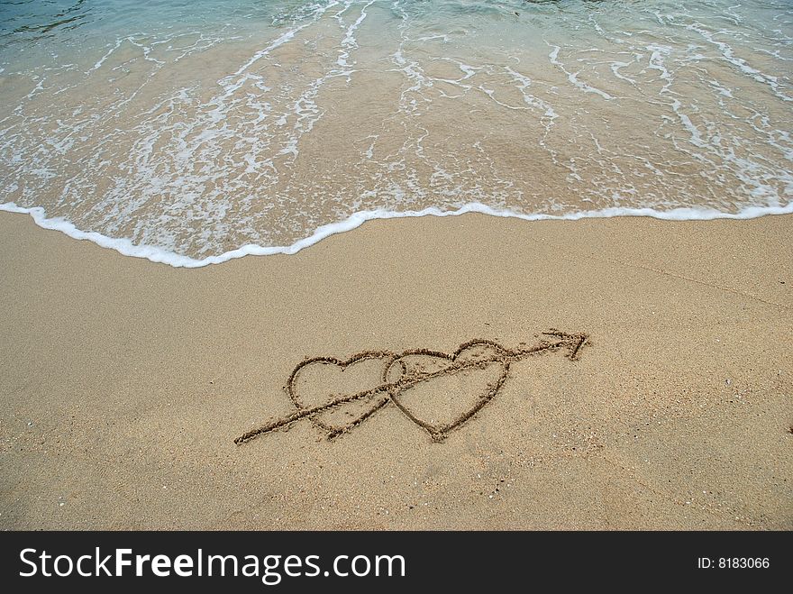 2 Hearts drawn on the surfy beach, concept of love. 2 Hearts drawn on the surfy beach, concept of love