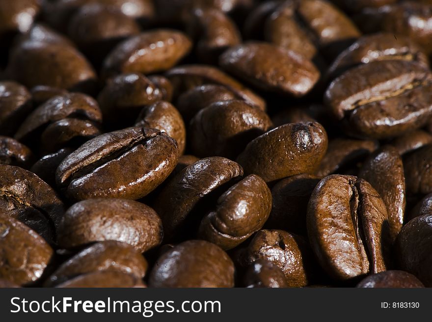 Fresh brown coffee beans background. Full frame. Shallow depth of field.