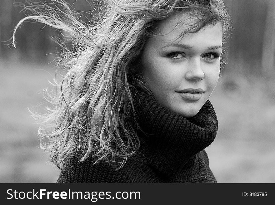 Black and white portrait of woman walking against wind with flowing hair. Black and white portrait of woman walking against wind with flowing hair