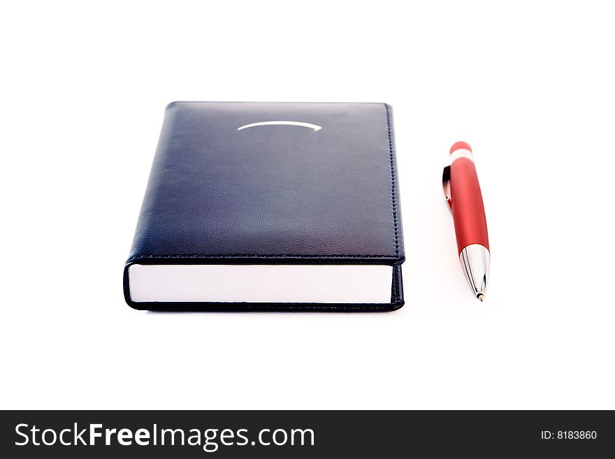 Notepad  with red ballpoint pen on white background