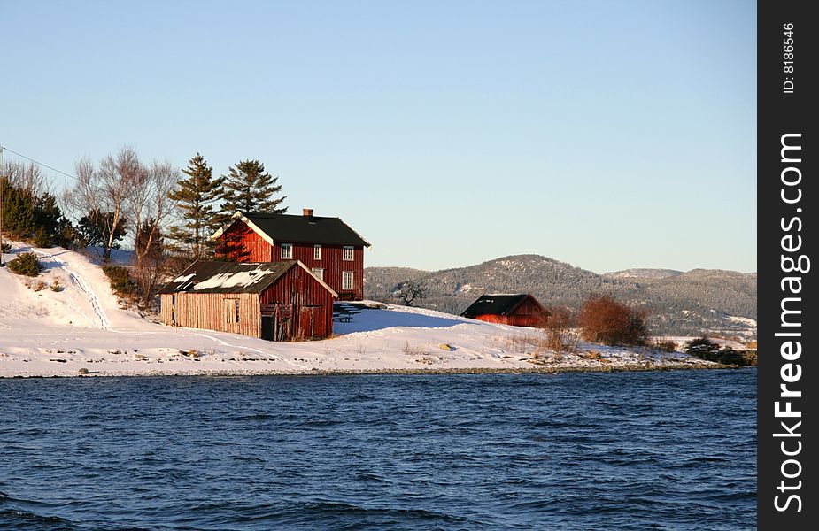 Old buildings on a shore by a fjord in winter. Old buildings on a shore by a fjord in winter