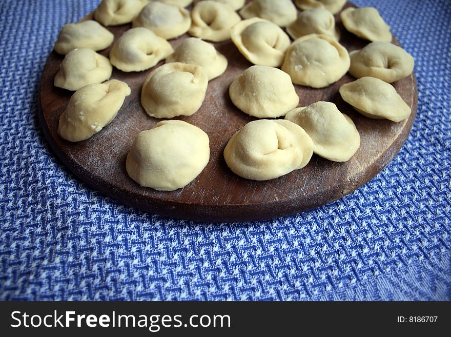 Pel'menis or raviolli with meat - a dish characteristic for the Italian, Russian, Ukrainian and Chinese kitchen. In this picture - the home made Russian pel'menis.