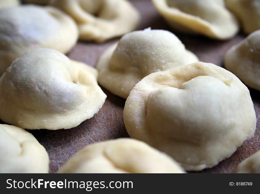 Pel'menis or raviolli with meat - a dish characteristic for the Italian, Russian, Ukrainian and Chinese kitchen. In this picture - the home  made Russian pel'menis.