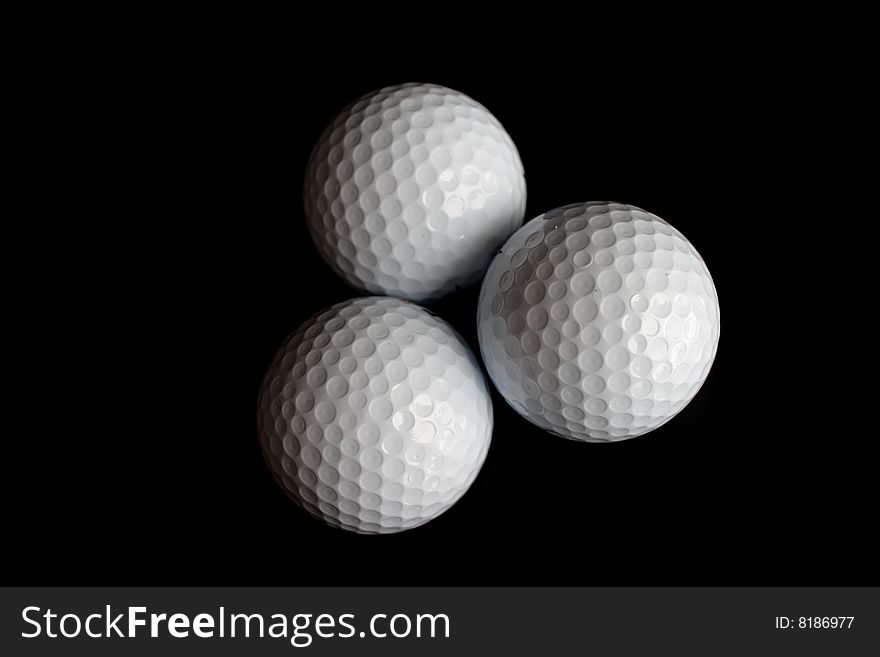 Three Golf balls on black background