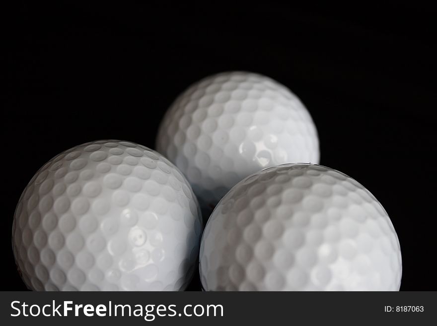 Three Golf balls on black background