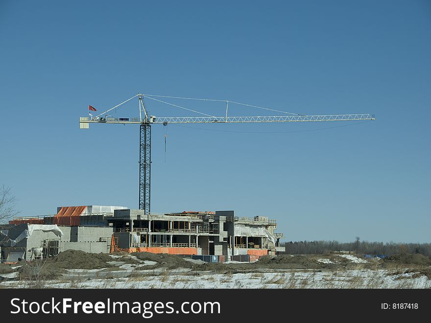Construction project with crane in winter with blue skies