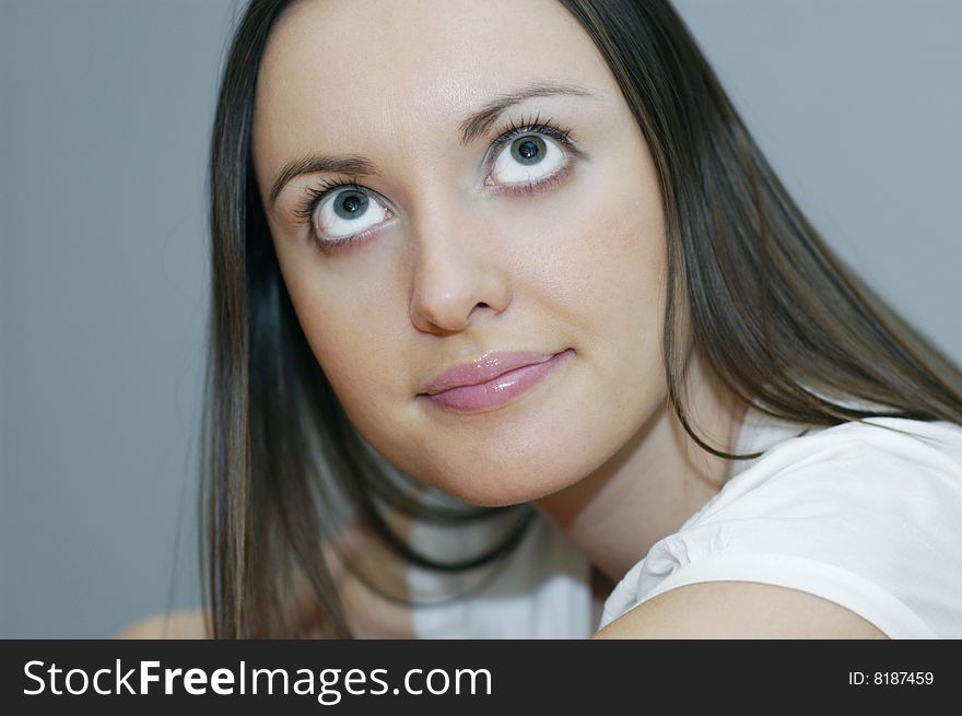 Woman with big eyes on grey background