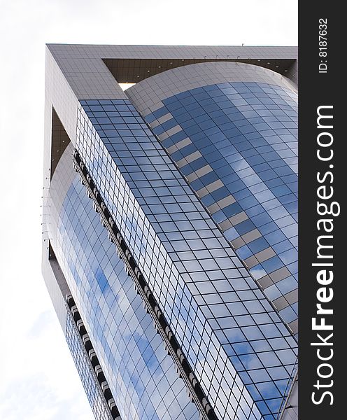 Blue office building with reflected clouds