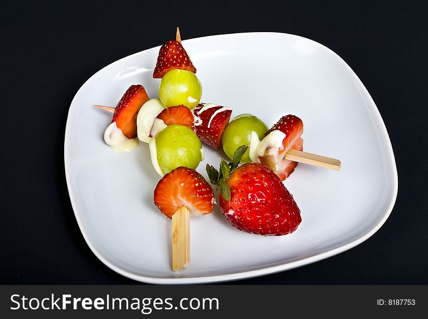 Strawberries and grapes on plate with cream