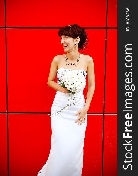 Funny bride by the red wall. Funny bride by the red wall