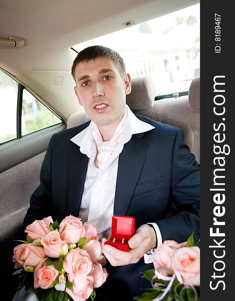 Groom with rings and flowers in the car. Groom with rings and flowers in the car