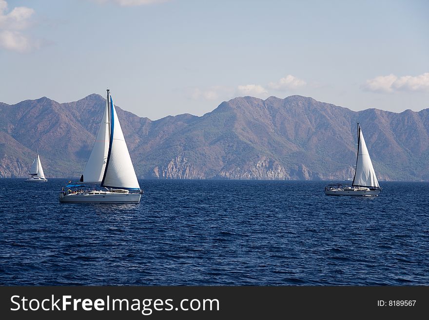 Sailboat at sea on a background mountains. Sailboat at sea on a background mountains