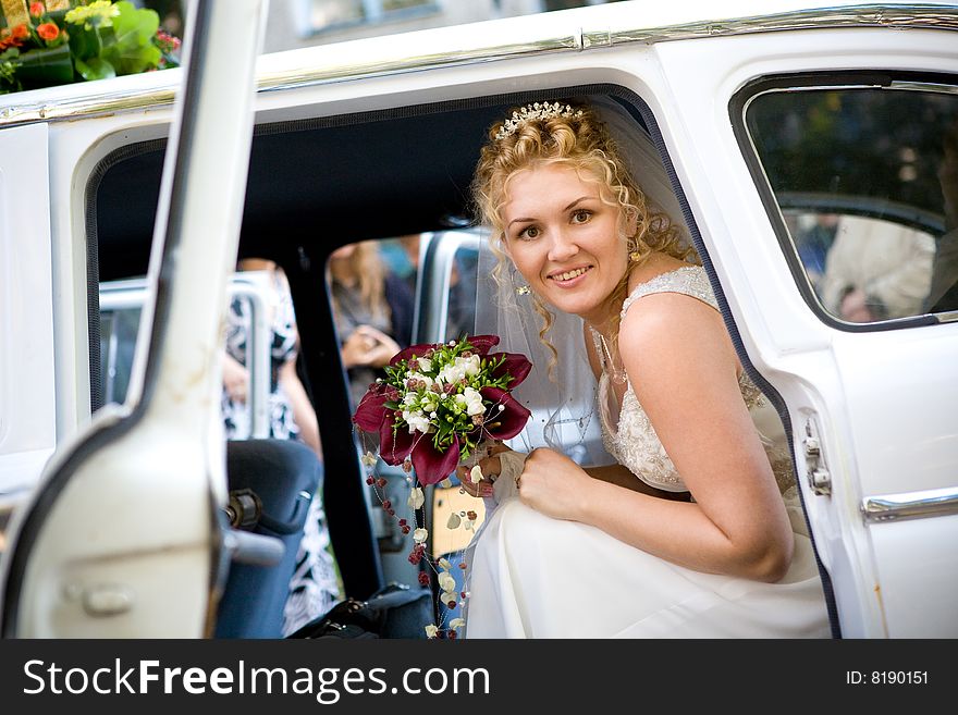 Happy bride with flower bouquet siting in the car. Happy bride with flower bouquet siting in the car