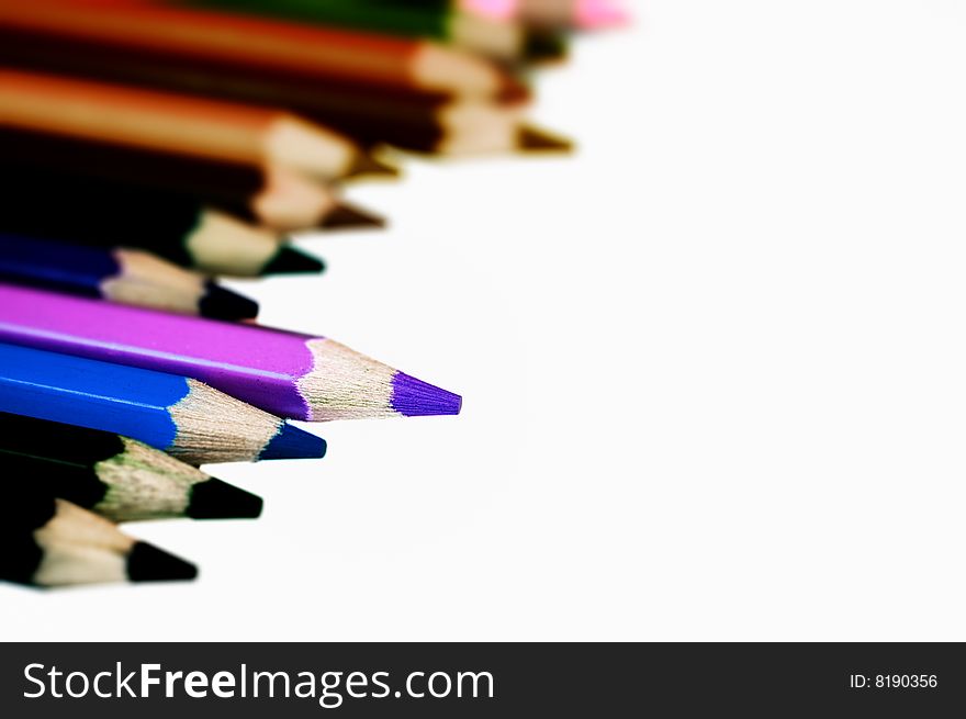 Coloring pencils isolated on white. Shallow depth of filed. Focus on purple pencil