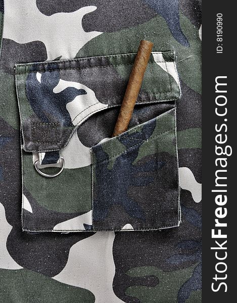 A cigar in the pocket of a camouflaged jacket.