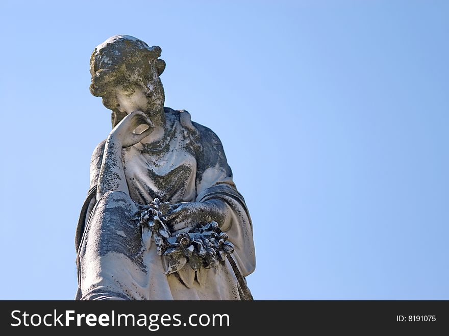 A cemetery statue of a sad woman with blue sky, location Mount Olivet Cemetery Nashville, TN copy space. A cemetery statue of a sad woman with blue sky, location Mount Olivet Cemetery Nashville, TN copy space