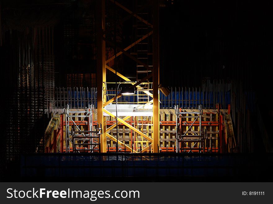 Construction site at night illuminated by to lights on crane tower. Construction site at night illuminated by to lights on crane tower