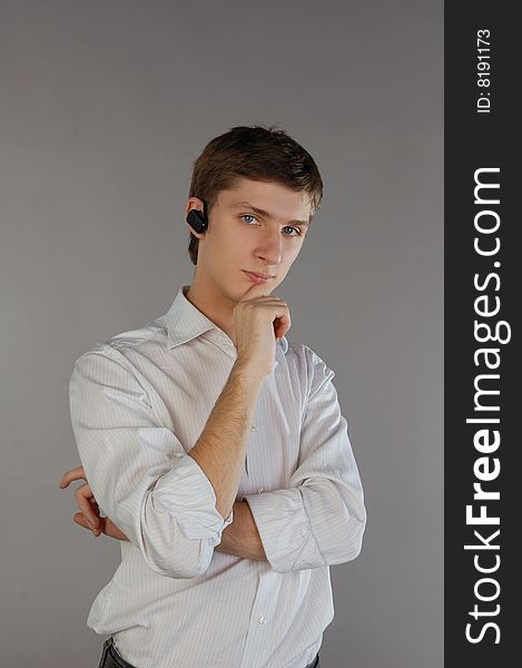 Standing young man with a bluetooth headset