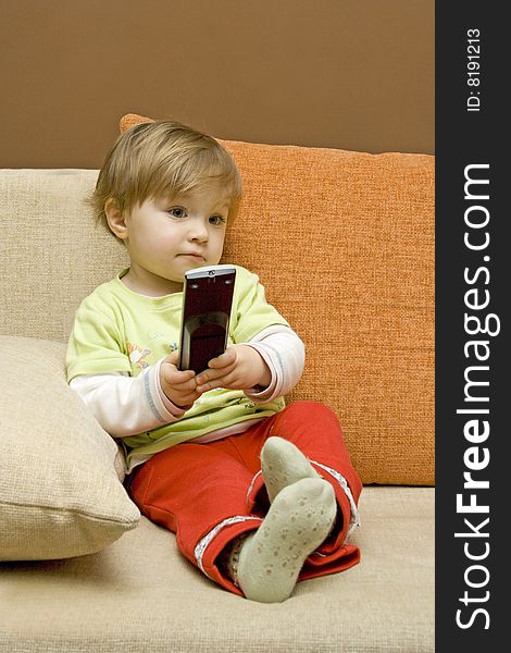 Baby girl with remote control on  sofa