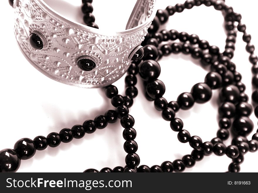 Bracelet and black necklace closeup on a white background