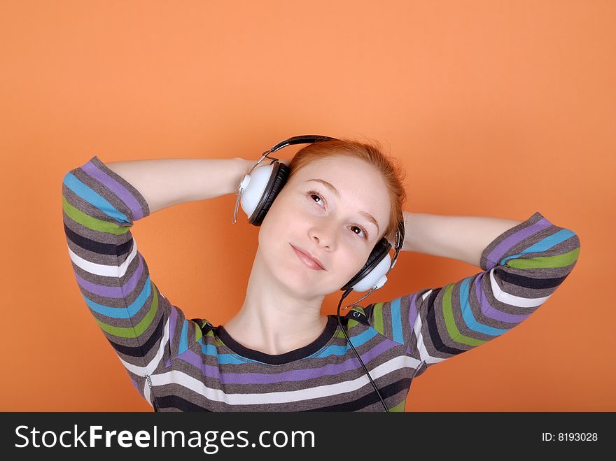 Redhead young woman in headphones with copy space