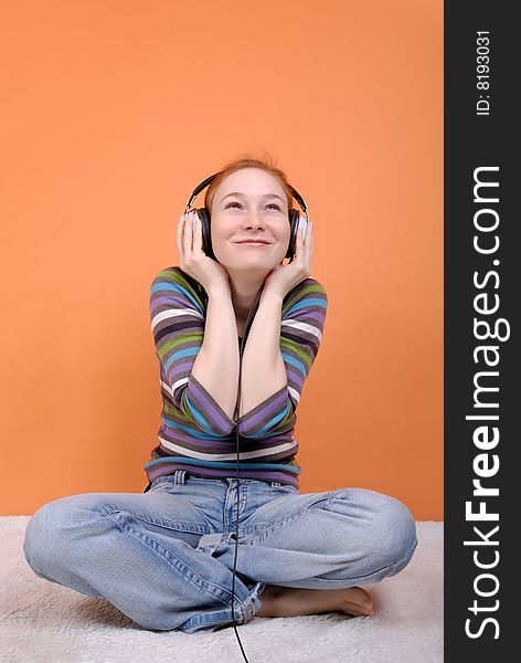 Redhead young woman in headphones with copy space