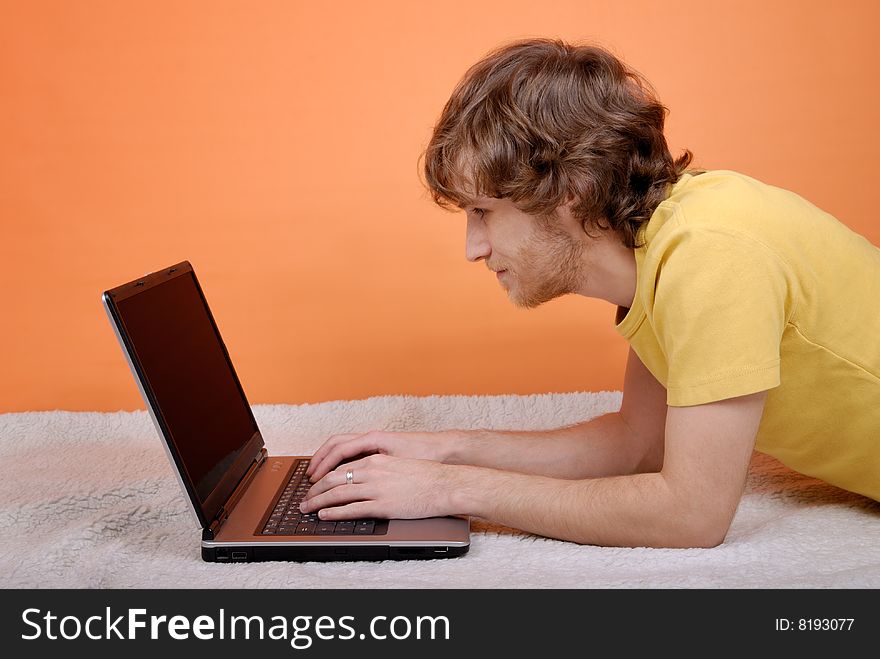 The man with the laptop on an orange background