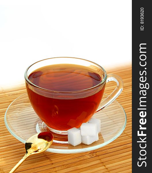 Glass Cup of Tea With Gold Spoon and Sugar Cubes