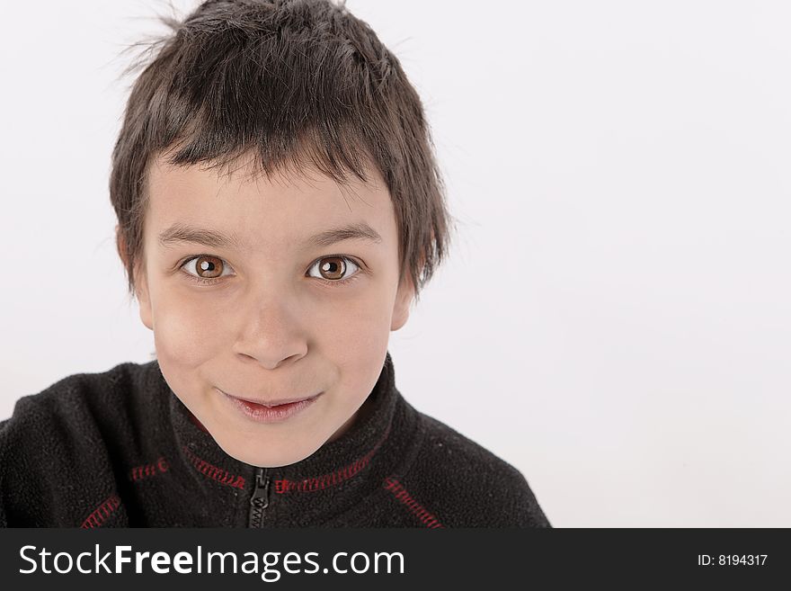 Young boy with shy smile and beautiful brown eyes. Focus on the eyes. Young boy with shy smile and beautiful brown eyes. Focus on the eyes