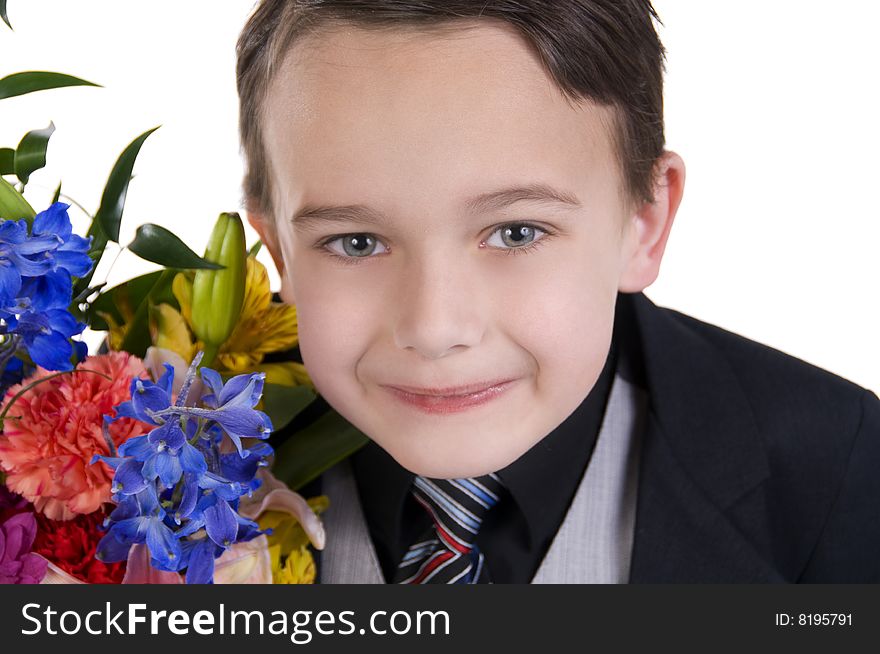 Image of small boy dressed in suit presenting flowers as a gift. Image of small boy dressed in suit presenting flowers as a gift