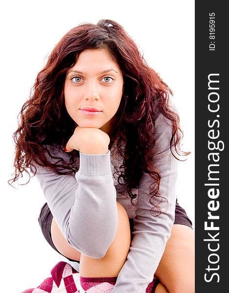 Gorgeous woman looking at camera while sitting with white background